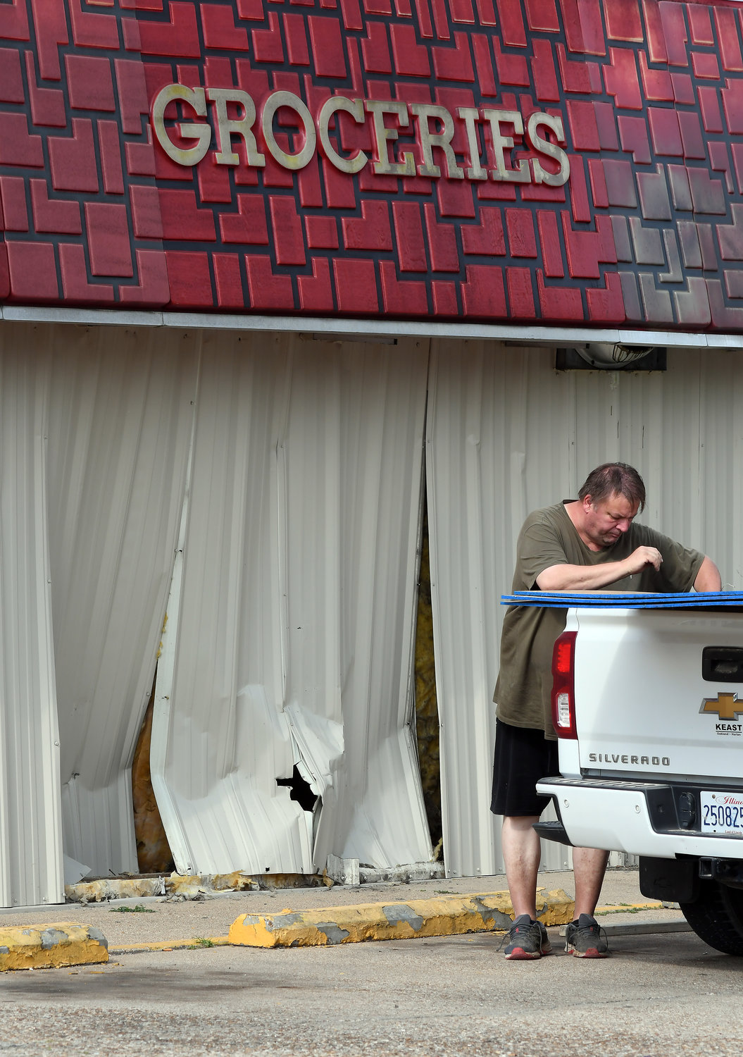 Russell Nelson with Bailey Construction of Sedalia, Mo., prepares to cover damage Monday afternoon to the Owensville Casey’s General Store building. A customer’s vehicle hopped the curb earlier in the day.